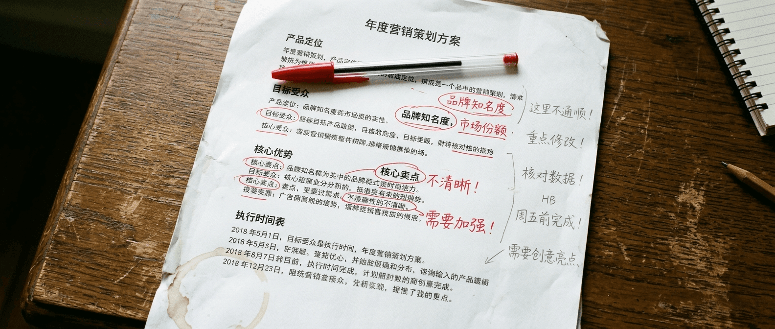 A printed sheet of Chinese marketing copy with a red pen resting on it, a few words circled, natural light on the desk