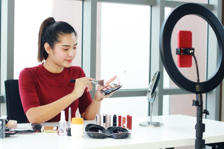 Beautiful Asian woman blogger holding eye shadow box